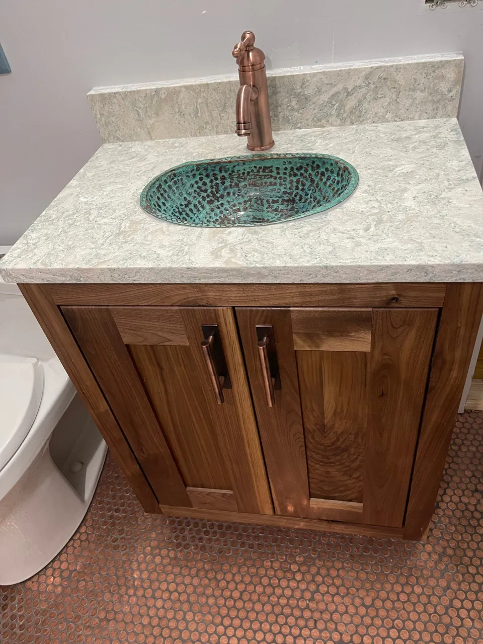 Bathroom vanity above a floor of real pennies