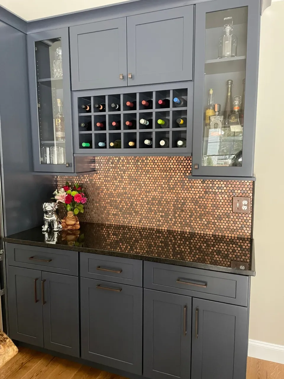 Gray kitchen cabinetry above a copper penny backsplash